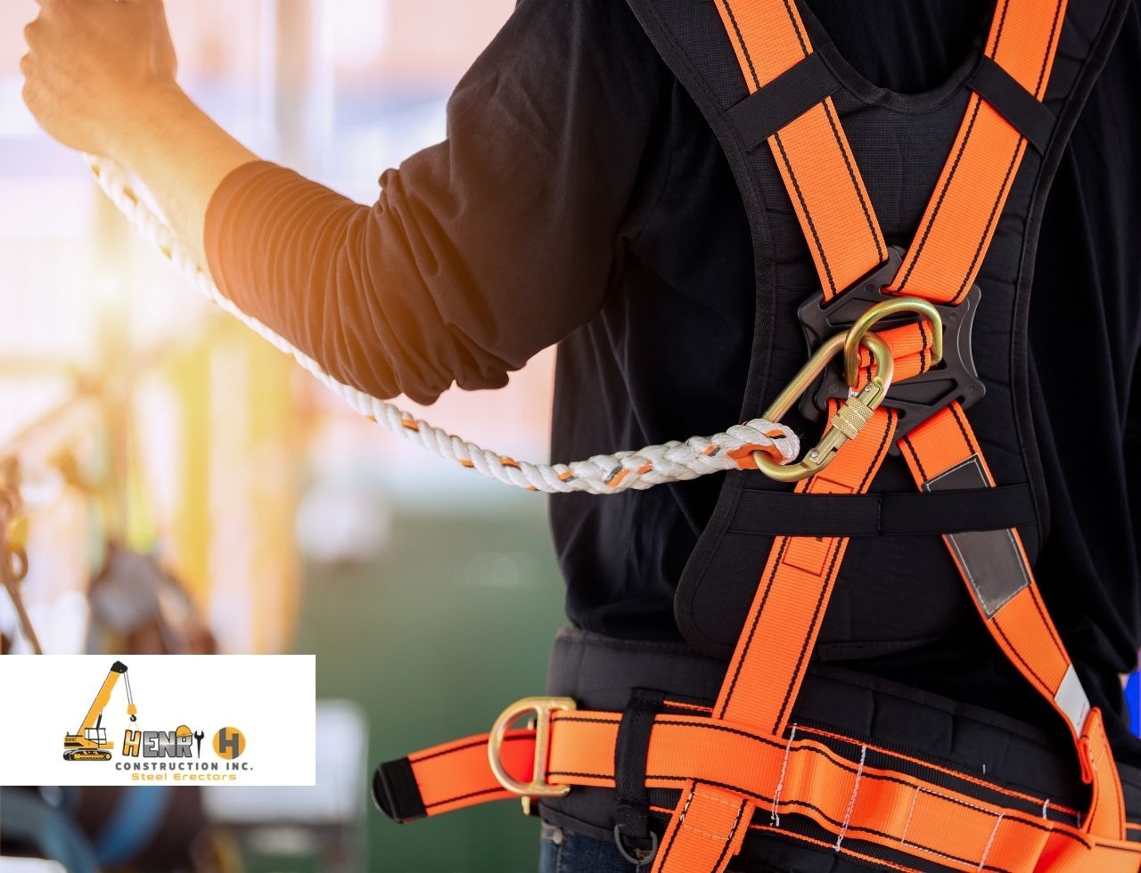 Worker inspecting fall arrest harness on a commercial jobsite