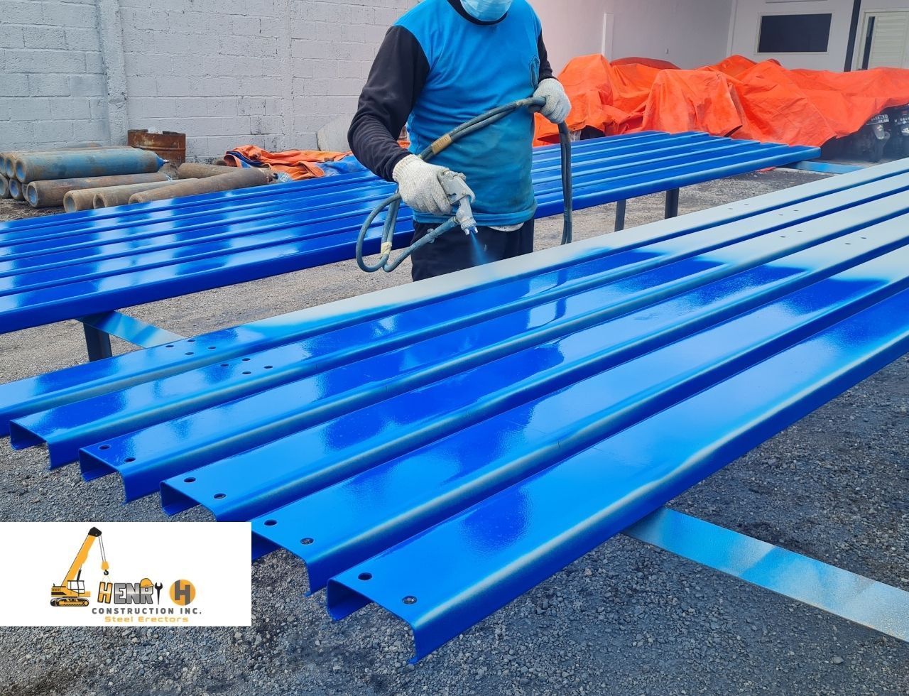 Worker applying anti-rust coating to steel beams